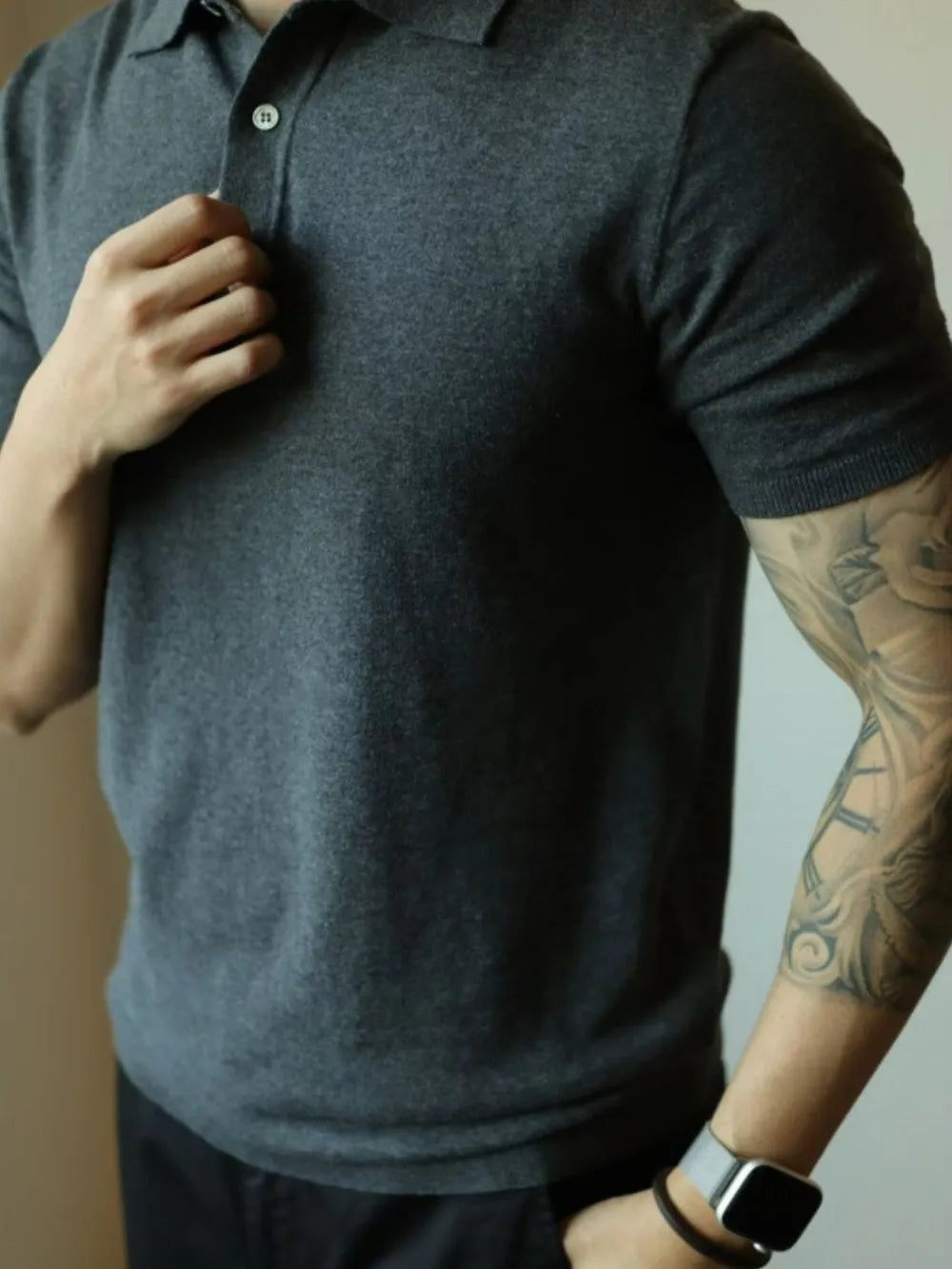 Dark gray fine-gauge knit polo shirt with a refined placket and button detail.