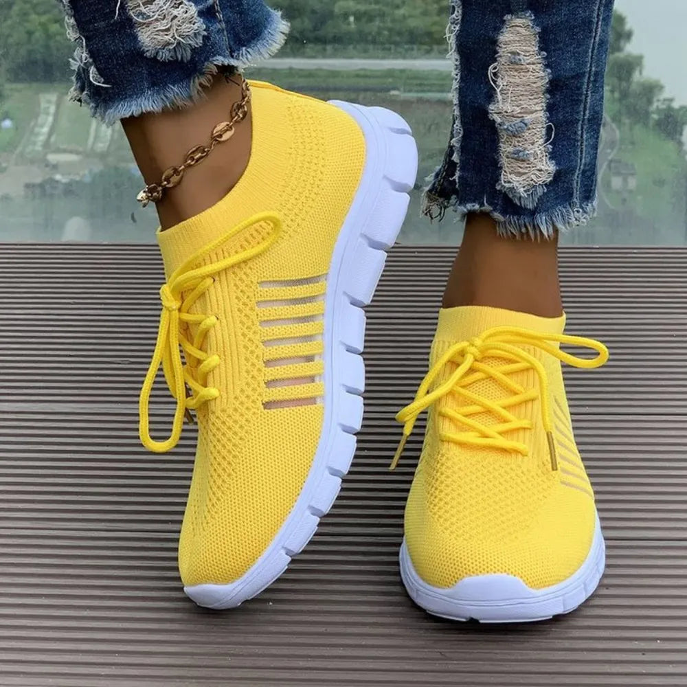 Yellow knit runner sneakers with white soles and stripe detail.