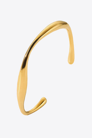 Gold 18K gold-plated open-ended bangle with a sculpted, fluid design.