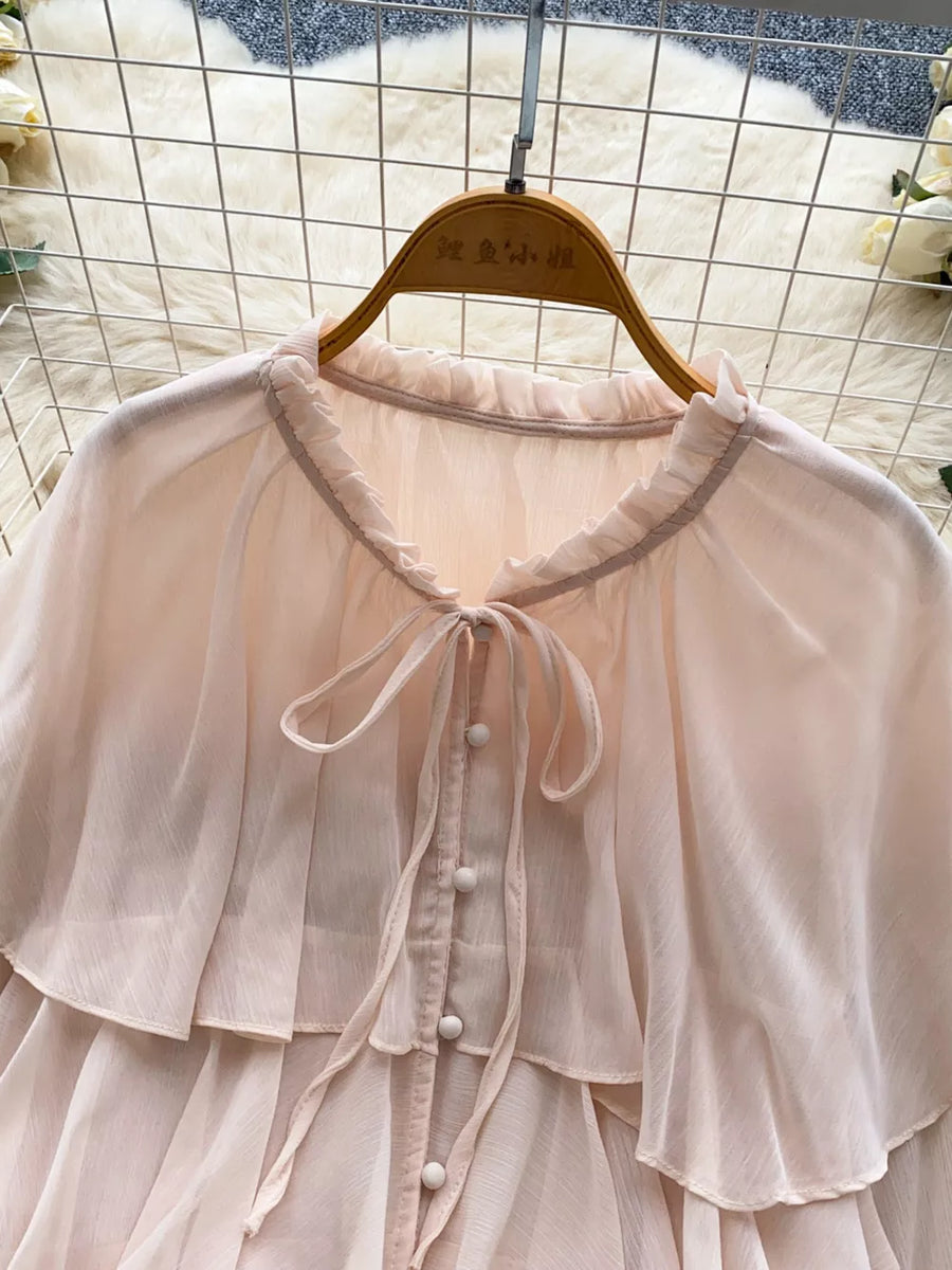 Pink chiffon blouse with ruffled neckline, tie detail, and button front.