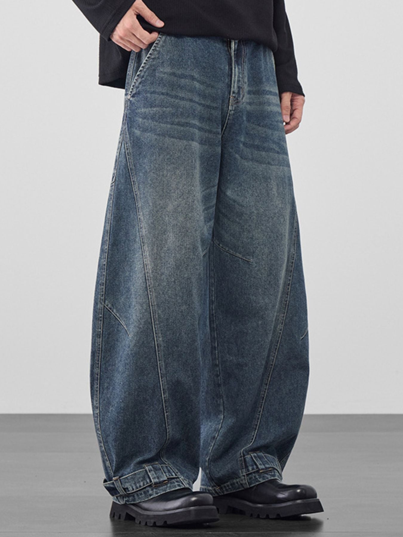 Men's baggy vintage wash jeans in dark blue denim with cinched hems.