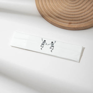 White headband with black dancing skeleton graphic