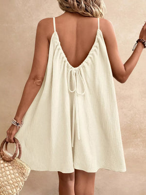 Light brown spaghetti strap gauze dress with tie-back detail and textured fabric.