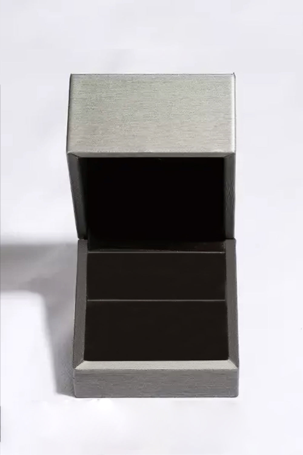 Silver ring box with open lid and dark interior