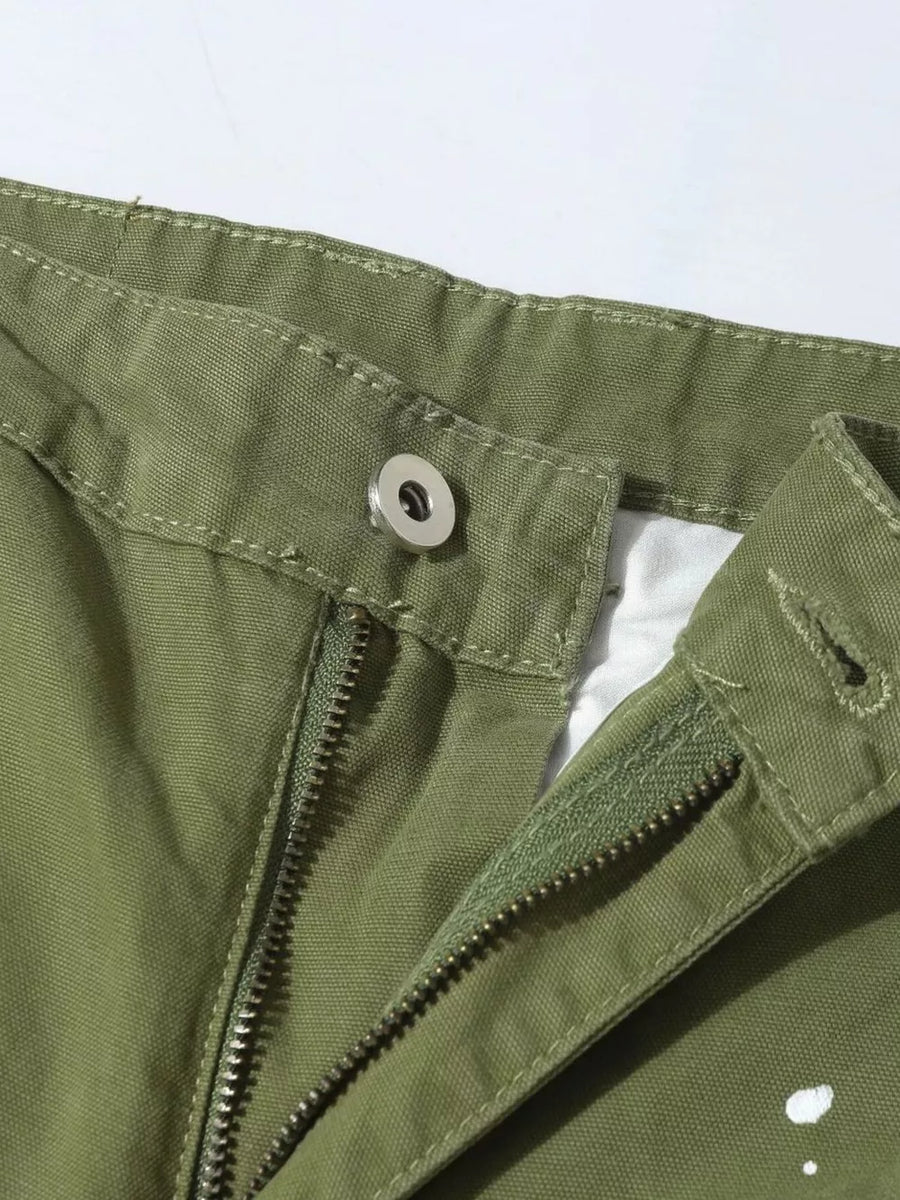 Green cargo pants with zipper fly, button closure, and distressed accents.