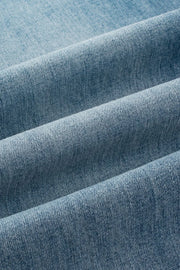 Button-fly wide-leg denim trousers in medium wash, showing fabric texture.