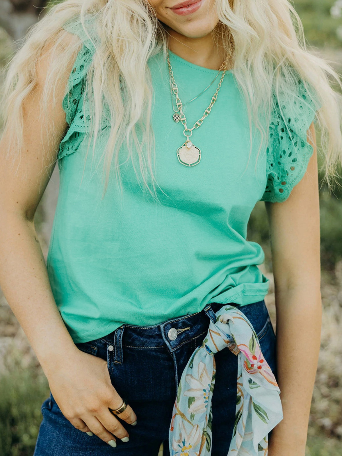 Eyelet lace cap sleeve top in green with ruffled details and a crew neck.