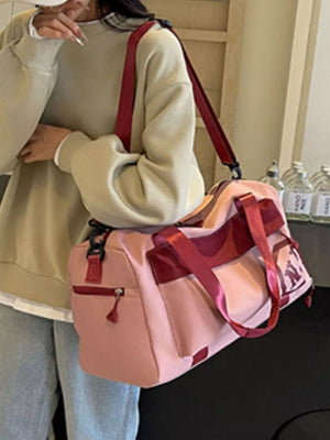 Pink Oxford cloth travel duffel bag with red accents and detachable strap.