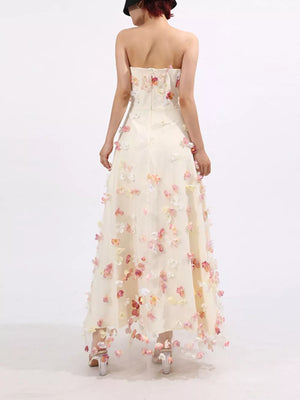 Strapless ivory tulle maxi dress with floral appliques, sweetheart neckline, A-line skirt.