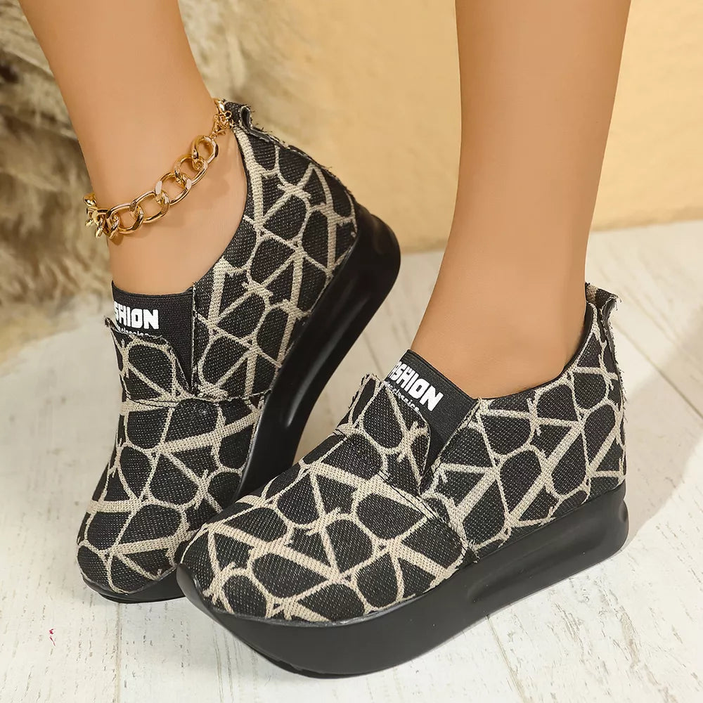 Geometric patterned black and beige slip-on sneakers with platform sole and white "FASHION" detail.