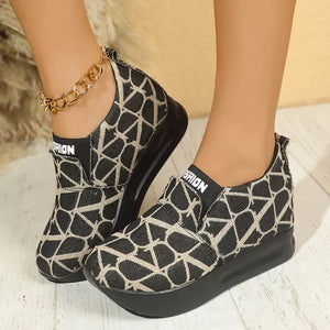 Geometric patterned black and beige slip-on sneakers with platform sole and white "FASHION" detail.