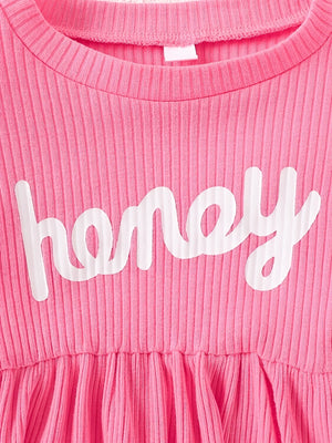 Pink ribbed baby dress with white "honey" graphic and gathered skirt