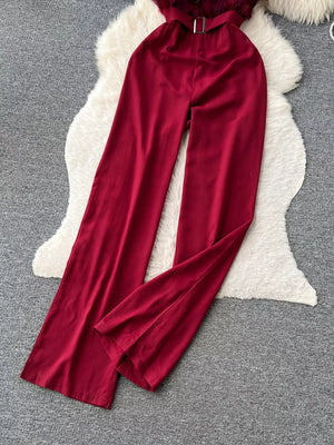Wine red belted strapless wide-leg jumpsuit with feather trim detail.