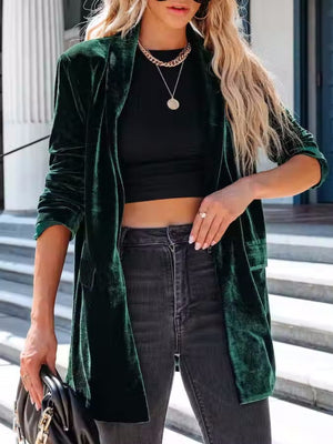 Dark green velvet blazer with a drape-front and button closure, styled with a black top and jeans.