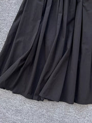 Black a-line skirt with gathered waist and pockets, shown up close.