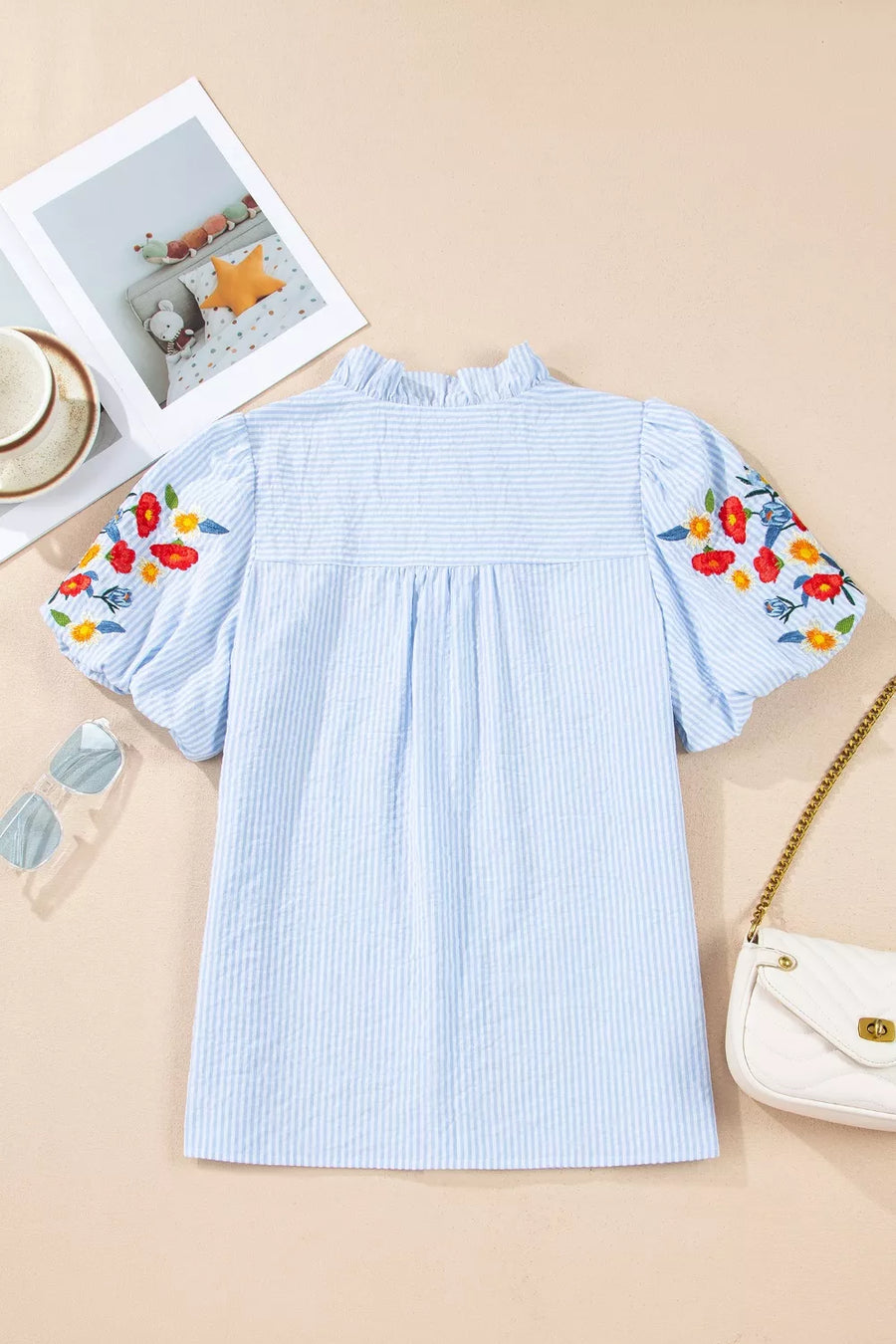 Light blue striped cotton shirt with embroidered floral puff sleeves and frill neckline.