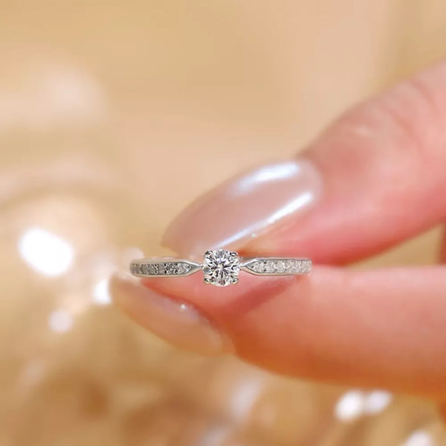 Elegant moissanite ring in sterling silver with a brilliant center stone and pave band.