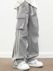 Oversized gray cargo pants with flap pockets and triple stripe detail.