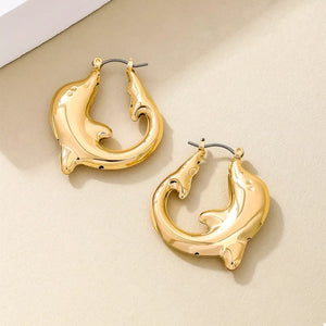 Gold dolphin hoop earrings with a sleek, polished finish.