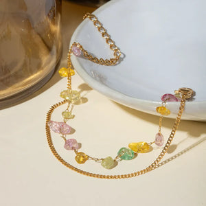 Gold double chain bracelet with colorful gemstone chips and 18K gold plating.