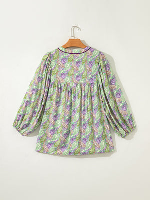 Paisley print puff sleeve blouse in green and purple with a gathered neckline and purple trim.