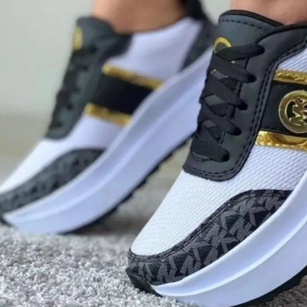Chic round toe platform sneakers in black and white with gold accents and monogram detail.