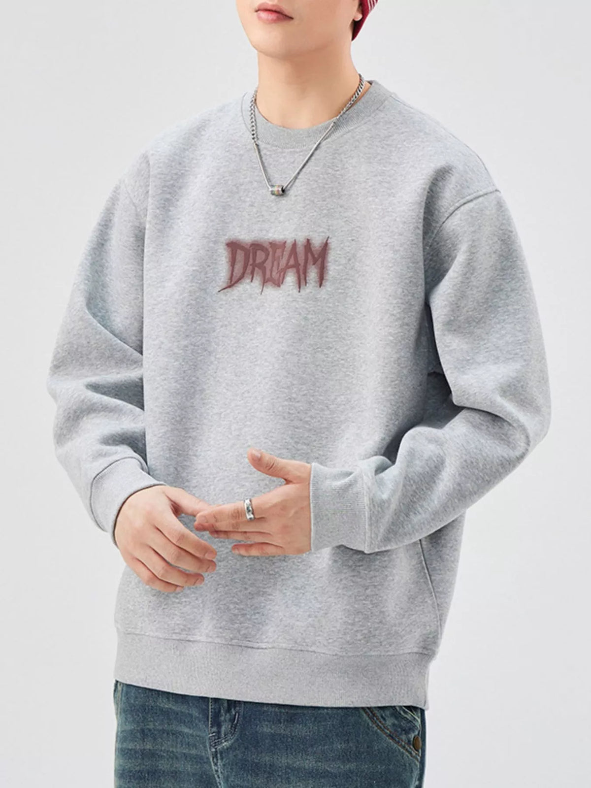 Oversized gray crew-neck sweatshirt with embroidered DREAM graphic.