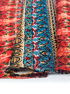 Bohemian maxi dress detail with red floral print and colorful tribal border fabric.
