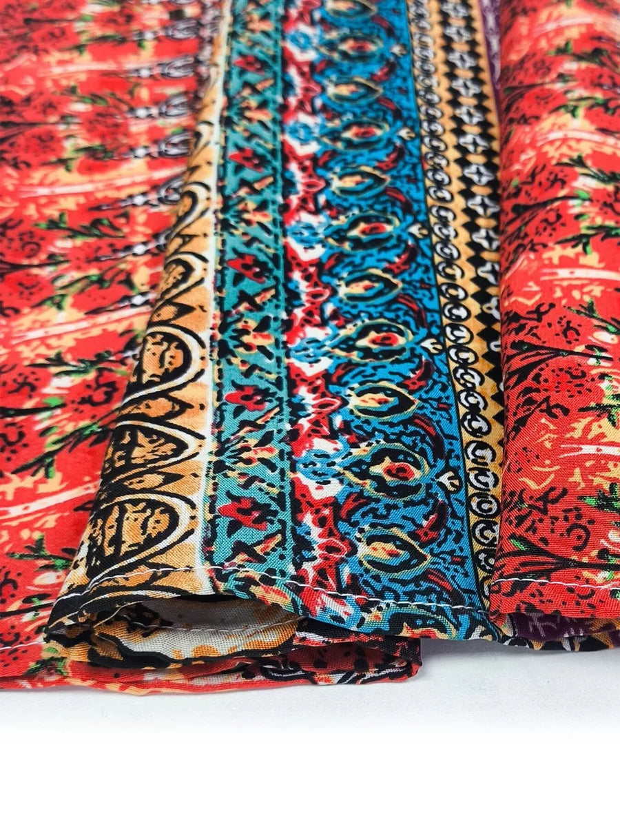 Bohemian maxi dress detail with red floral print and colorful tribal border fabric.