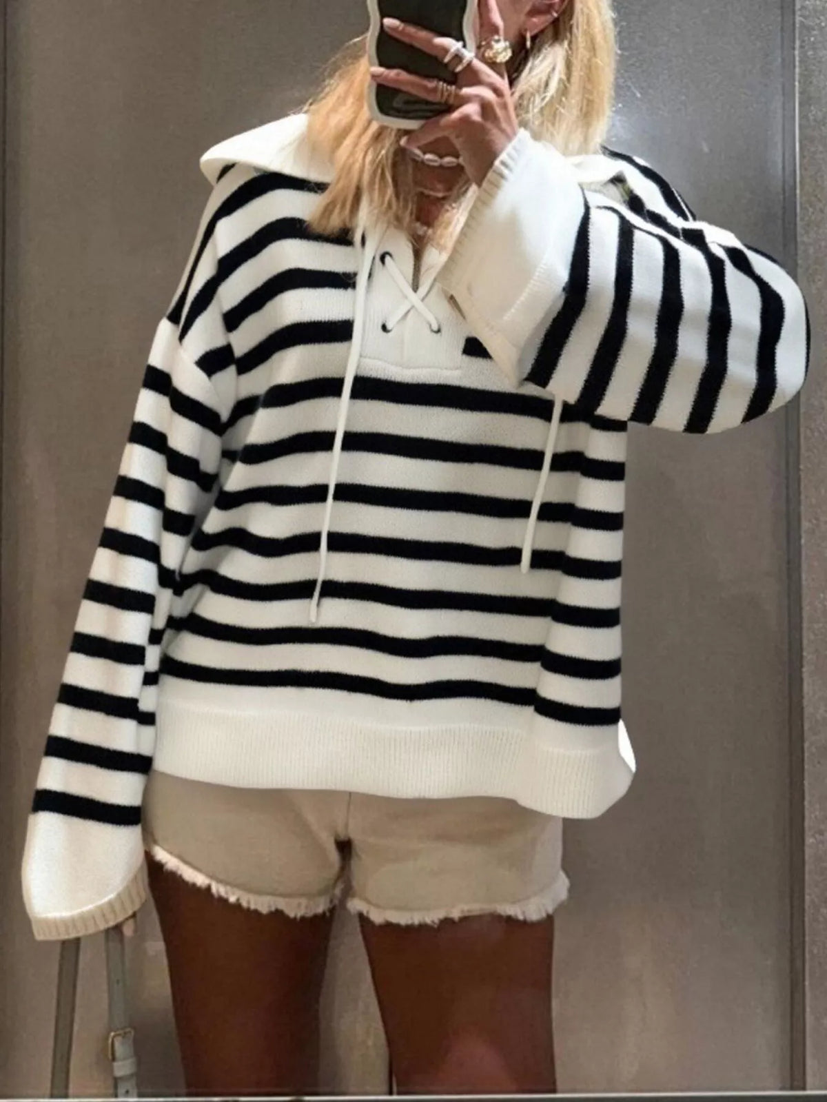 Black and white striped long-sleeve sweater with lace-up neckline and collar.