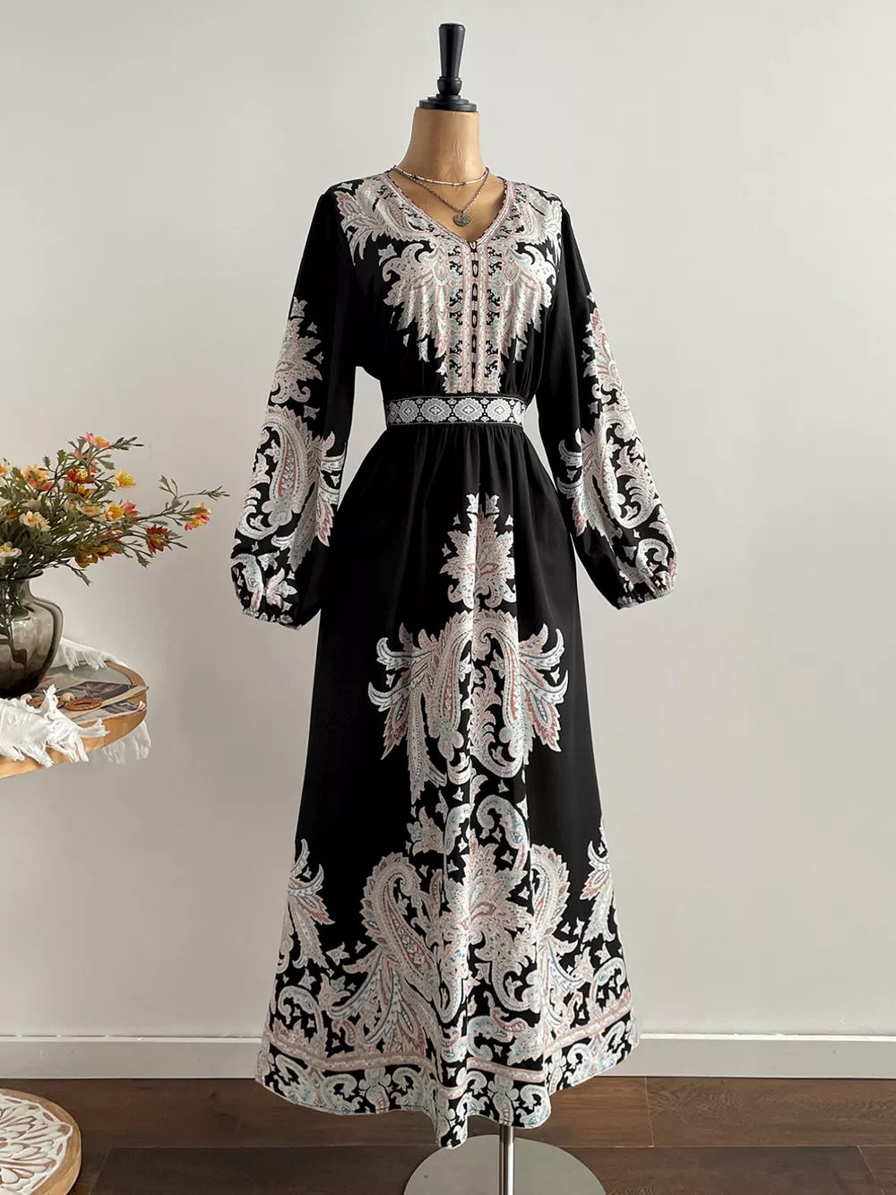 Black maxi dress with V-neck, balloon sleeves, and ornate paisley print.