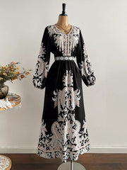 Black maxi dress with V-neck, balloon sleeves, and ornate paisley print.