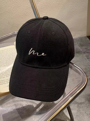 Black baseball cap with embroidered white "me" lettering