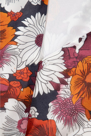 Floral wrap mini dress with puff sleeves in a bold floral print featuring white, orange, and burgundy flowers on a dark