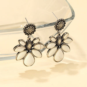 White petal drop earrings with silver alloy floral accents and a sunburst detail.