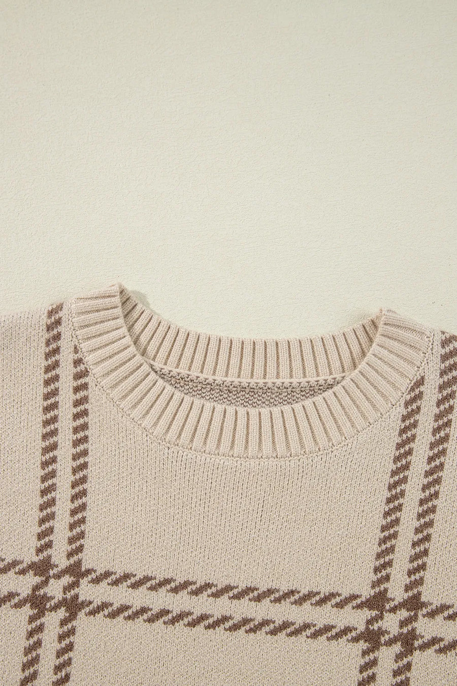 Tan crewneck knit pullover sweater with a brown gridline pattern and ribbed neckline.