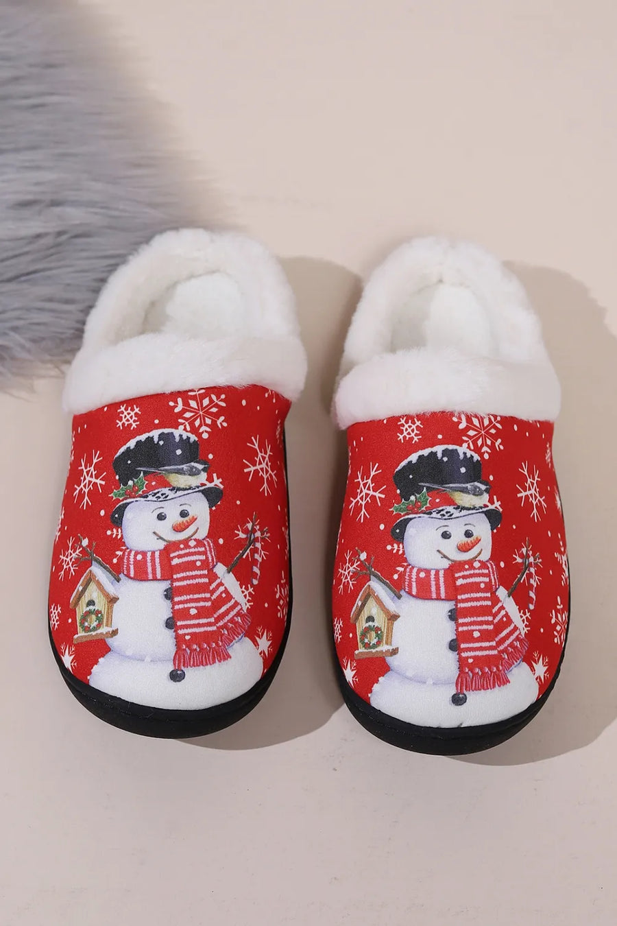 Red snowman print faux fur lined slippers with snowflake pattern.