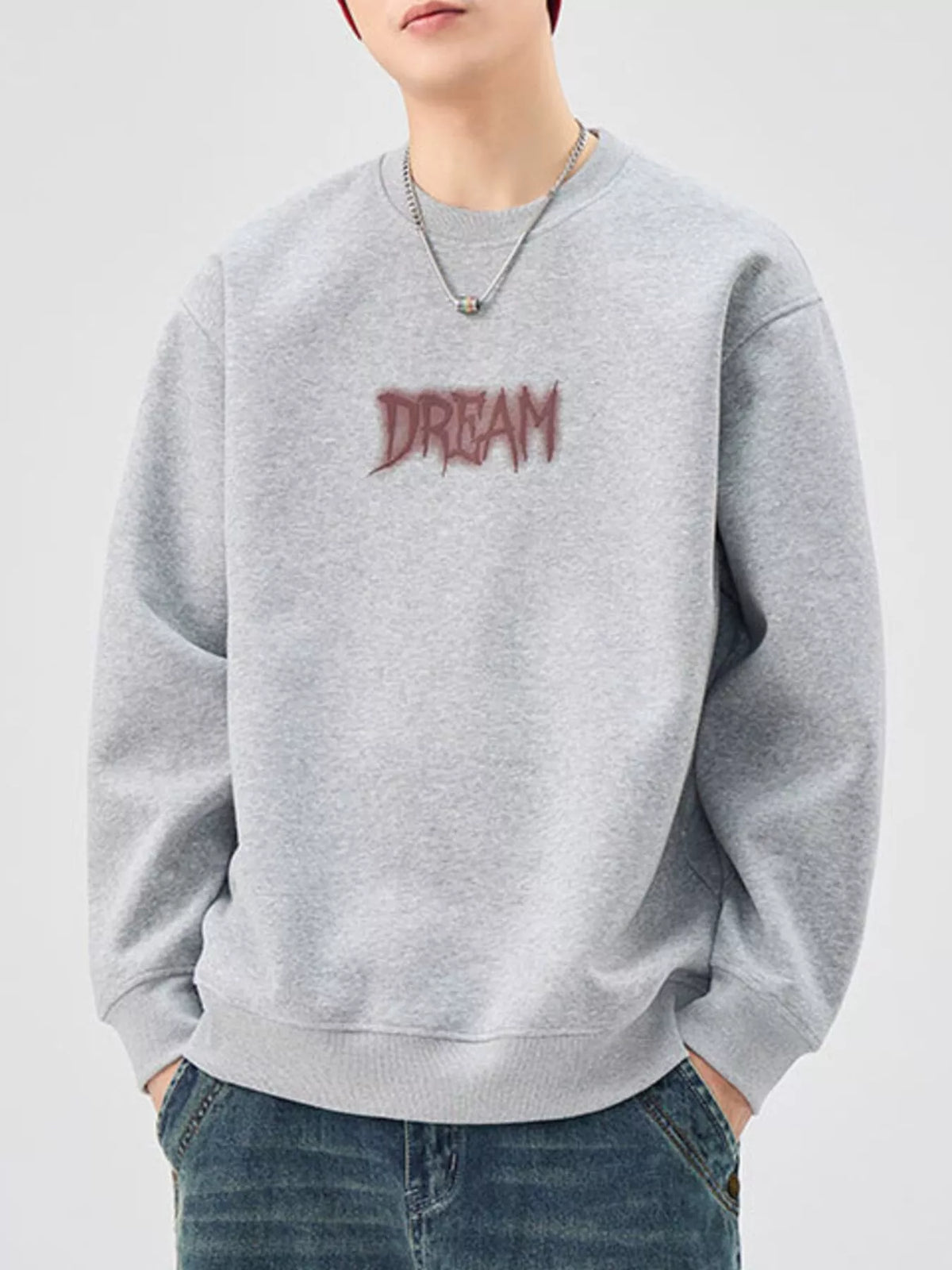 Oversized gray crew-neck sweatshirt with red "DREAM" graphic, cotton blend.