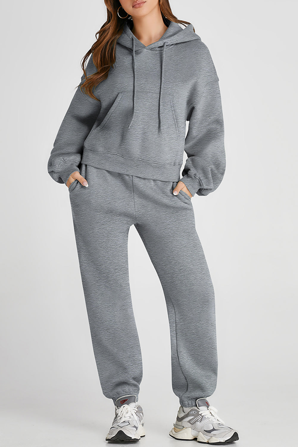 Gray relaxed fit loungewear set with hoodie and drawstring pants, featuring pockets.