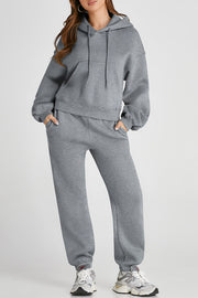 Gray relaxed fit loungewear set with hoodie and drawstring pants, featuring pockets.