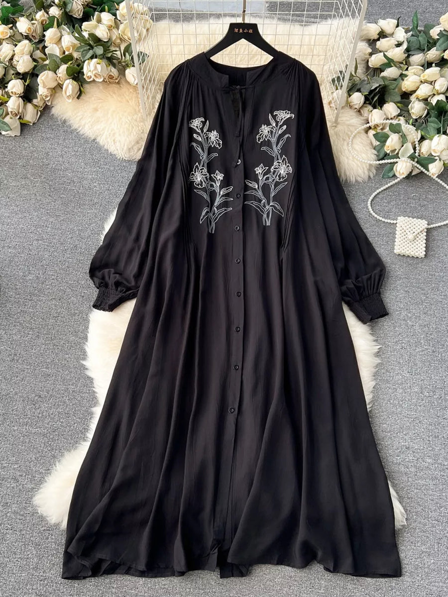 Black embroidered floral maxi dress with tie neck and balloon sleeves.