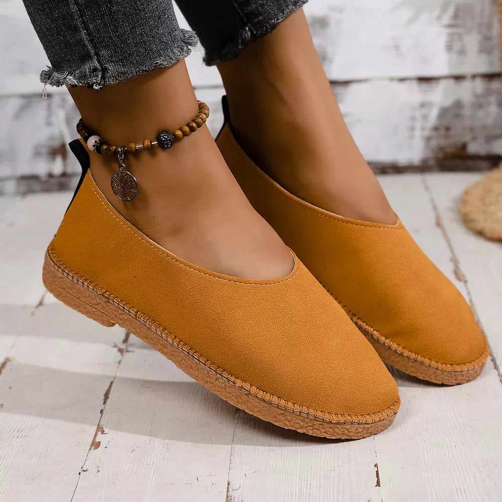 Yellow suede round toe comfort flats with contrast stitching and a beaded anklet.