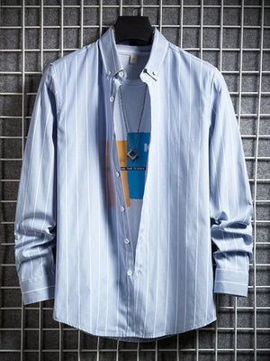 Blue striped long sleeve button-down shirt layered over a graphic tee.
