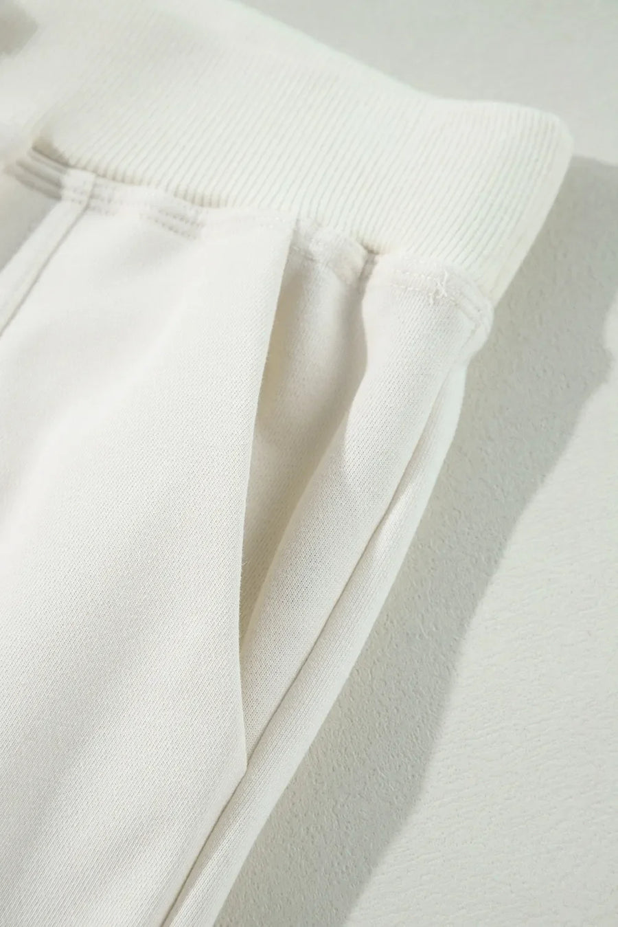 Ivory cargo pants with wide leg silhouette and side pockets.