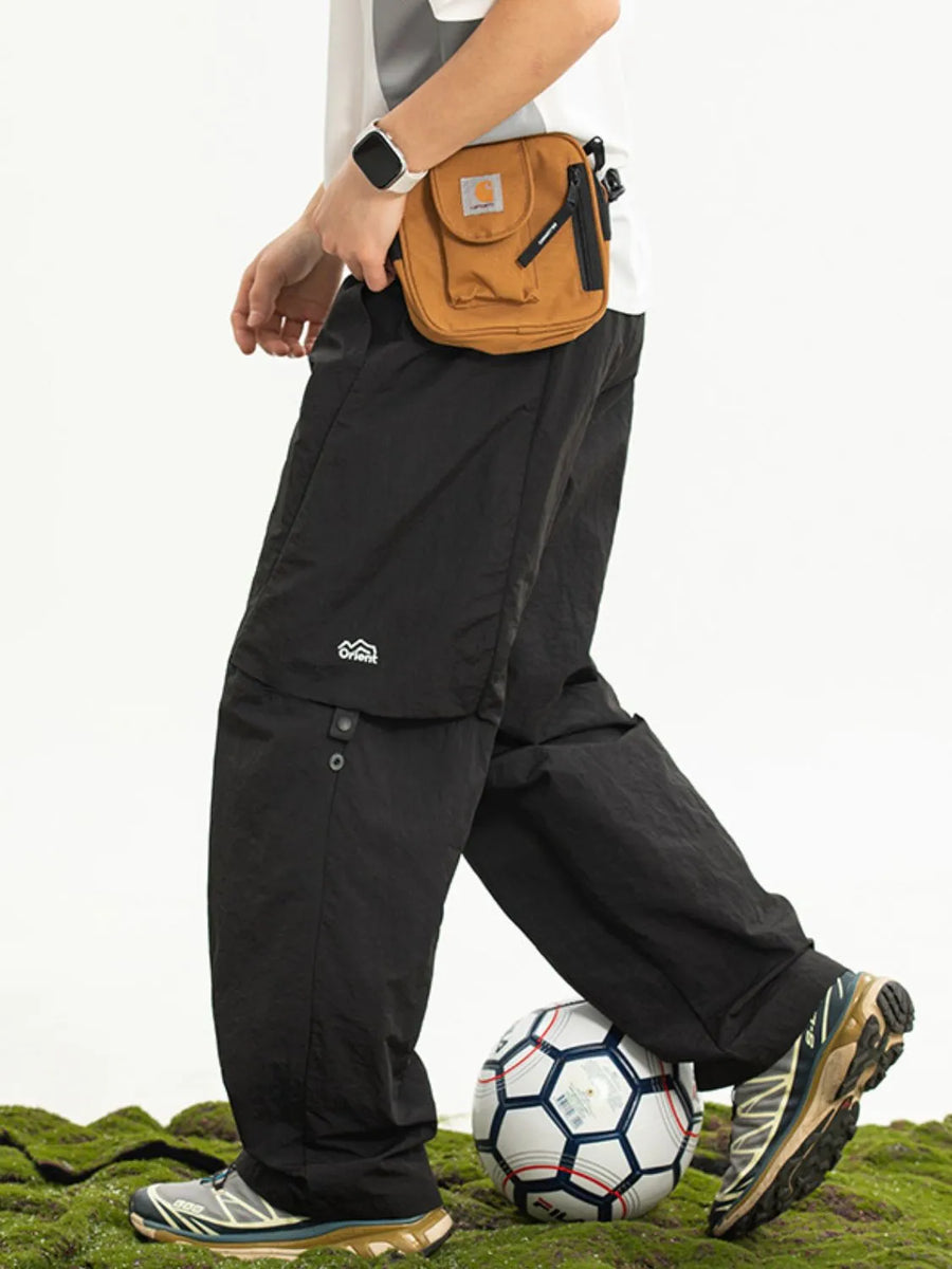 Black convertible cargo pants with zip-off legs and side logo detail