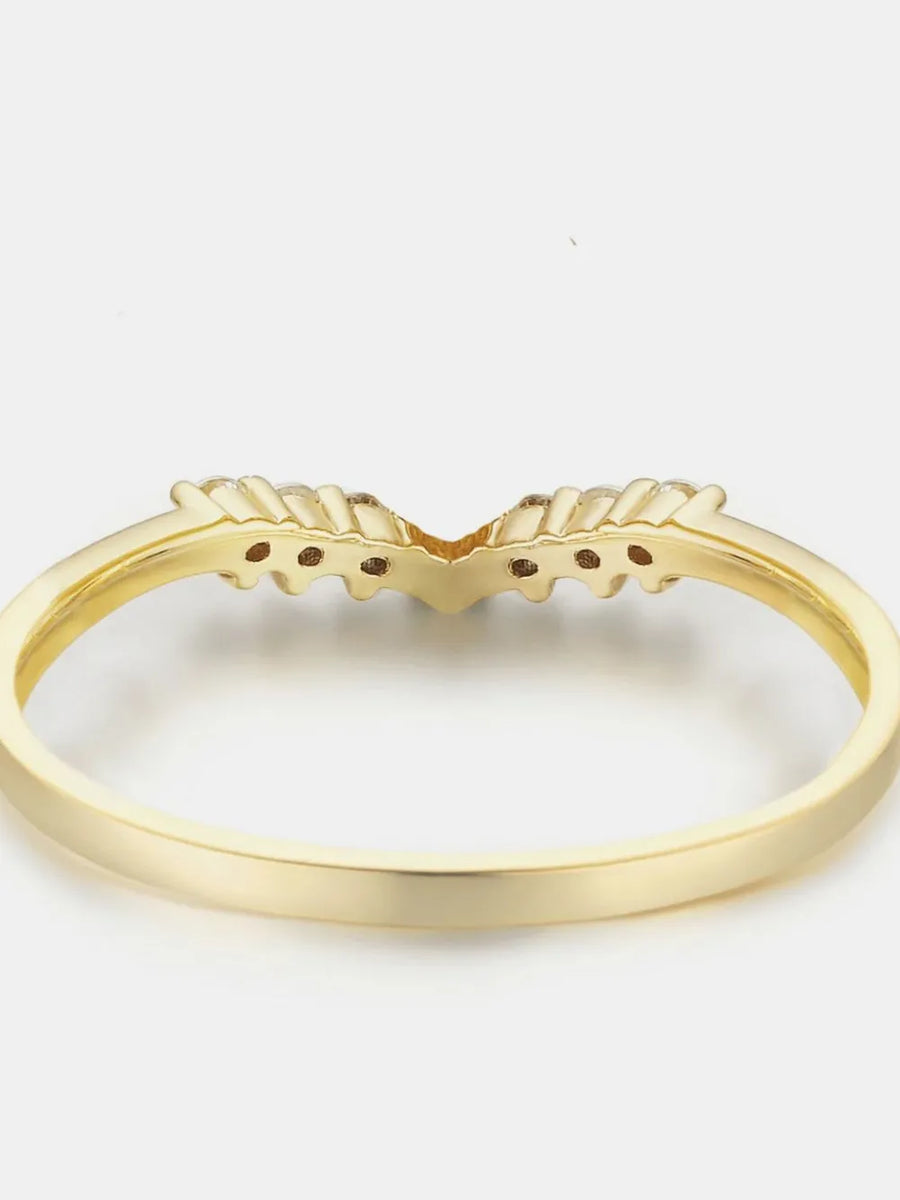 Gold chevron diamond band ring with v-shaped setting and small accent stones.