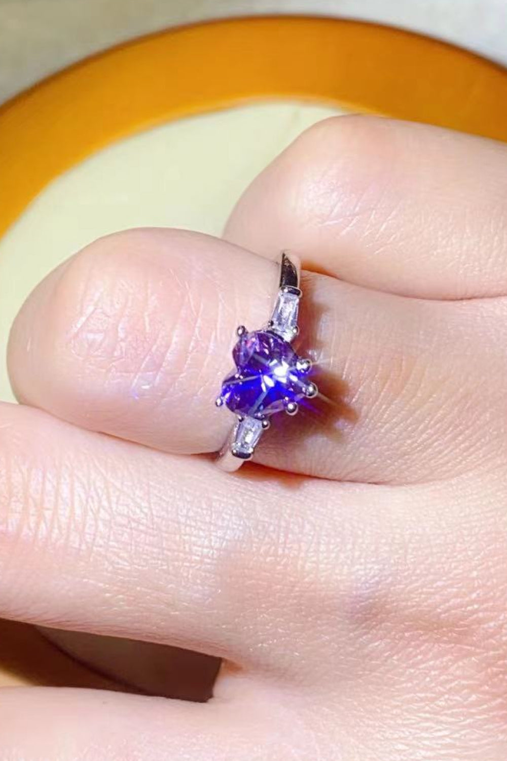 Purple heart-cut moissanite and baguette platinum ring.
