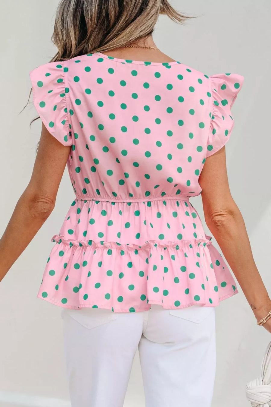 Pink polka dot blouse with ruffled sleeves and tiered hem