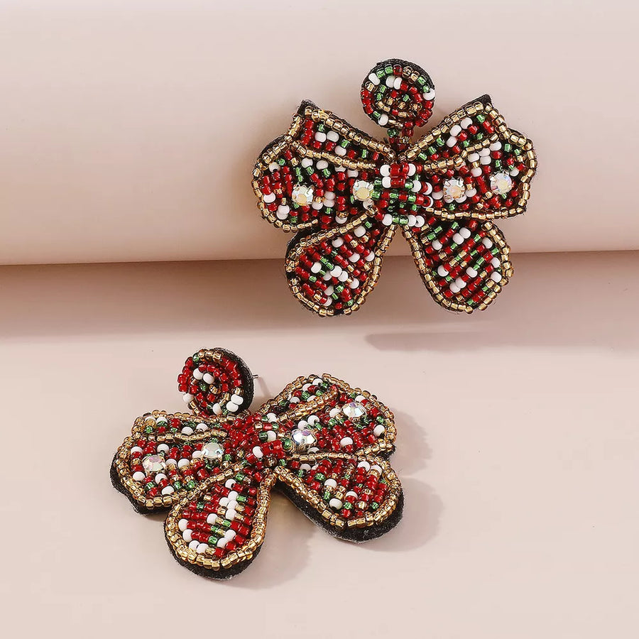 Acrylic, Rice beads, Crystal beads, PU base Care instructions: 1 earrings in gold with bowknot silhouette