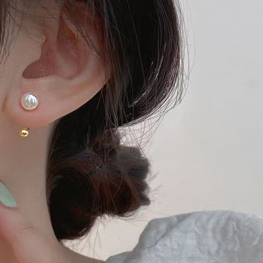 Sterling pearl stud earrings with gold back ball detail.
